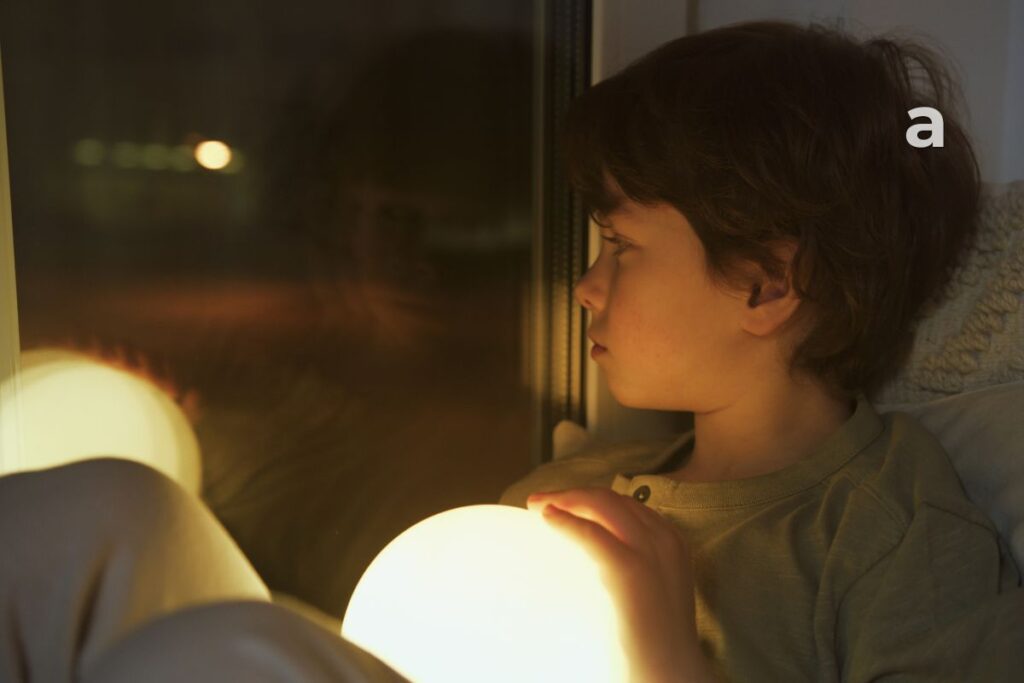 child looking through a window imagining future dreams that grow with time