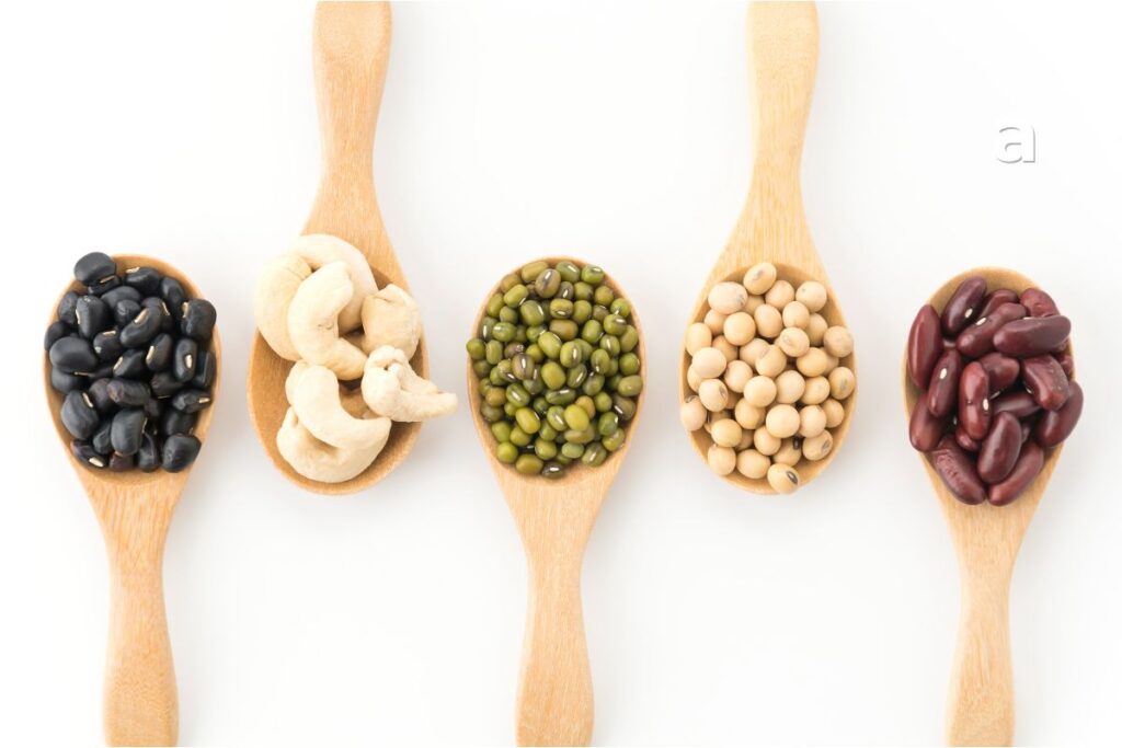 Collection of high-protein foods including chicken, salmon, eggs, lentils, tofu, beans, yogurt, nuts, and seeds.