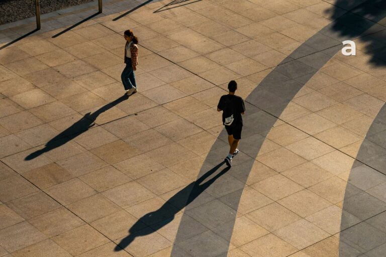 Two people walking in different directions on a quiet path, symbolizing outgrowing people, changing relationships, and personal growth.
