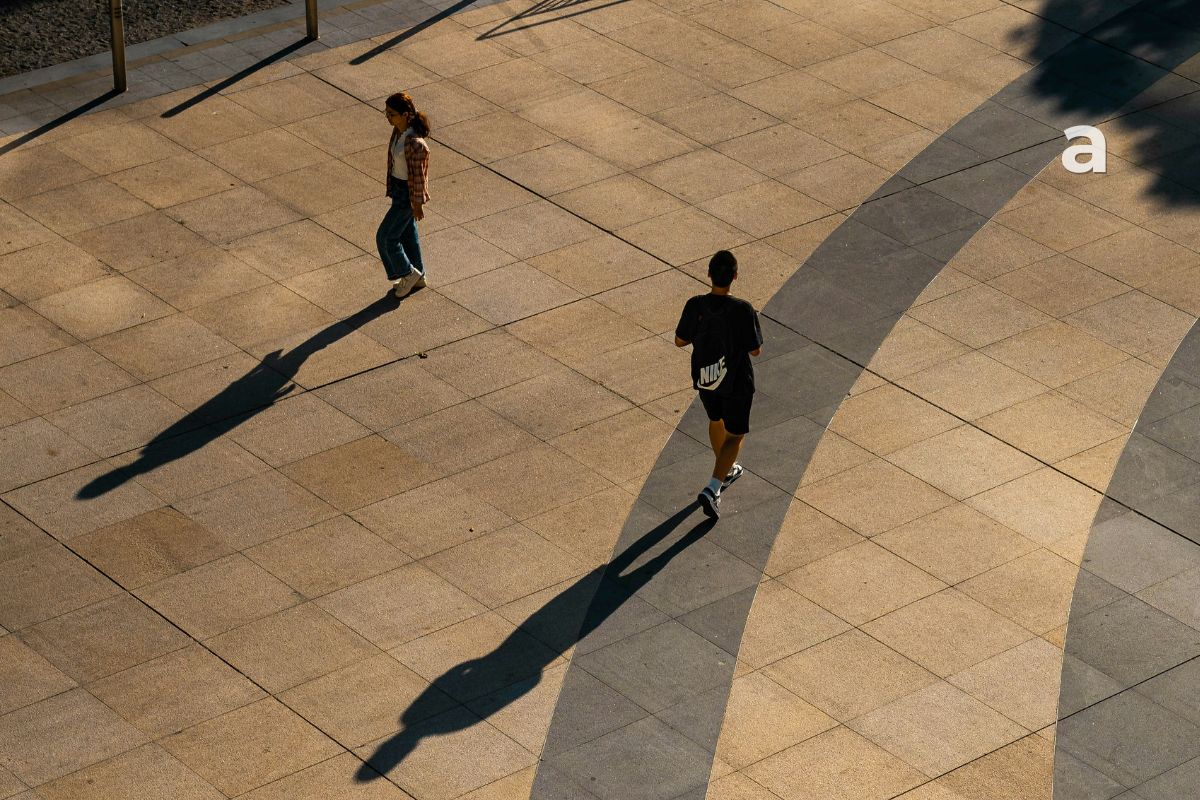 Two people walking in different directions on a quiet path, symbolizing outgrowing people, changing relationships, and personal growth.